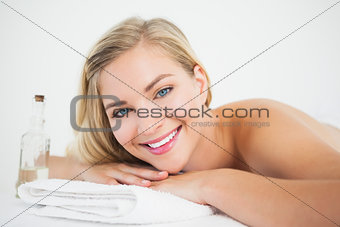 Beautiful blonde lying on massage table smiling at camera