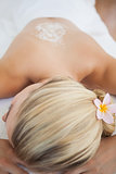 Beautiful blonde lying on massage table with salt scrub treatment