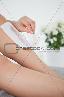 Woman waxing her legs herself