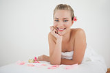 Pretty blonde lying on massage table with rose petals