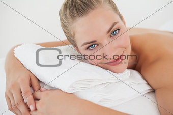Pretty blonde lying on massage table smiling at camera