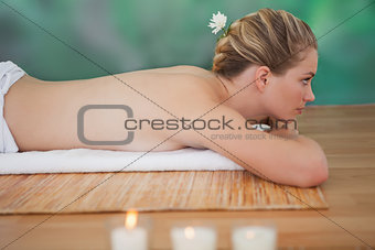 Peaceful blonde lying on bamboo mat