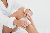 Woman waxing leg at spa center