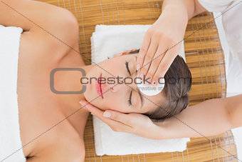 Hand cleaning woman's face with cotton swab