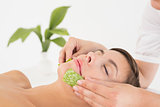 Attractive woman receiving aloe vera massage at spa center