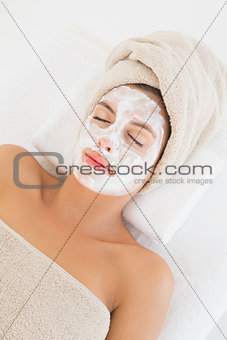 Attractive having white cream on her face at spa center