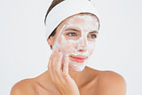 Attractive woman having white cream on her face