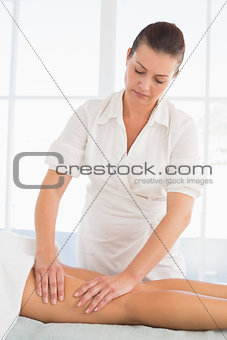 Female masseur massaging woman's leg