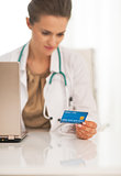 Closeup on doctor woman using credit card