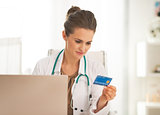 Doctor woman with credit card making online shopping
