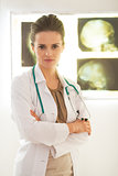 Portrait of confident doctor woman in front of lightbox