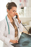 Doctor woman with fluorography talking phone
