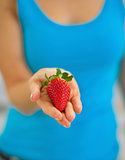 Closeup on young woman showing strawberry