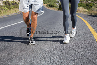 Fit couple running together up a road