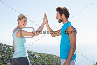 Fit couple standing high fiving