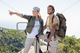 Hiking couple pointing and looking at mountain summit