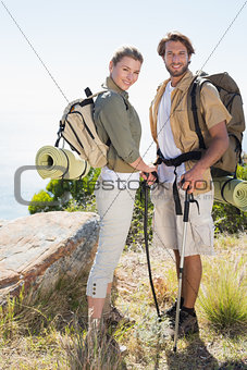 Hiking couple smiling at camera at mountain summit
