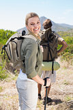 Attractive hiking couple walking on mountain trail woman smiling at camera