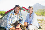 Attractive hiking couple smiling at camera outside their tent