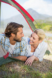 Attractive couple smiling at each other from inside their tent