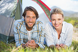 Attractive couple smiling at camera from inside their tent