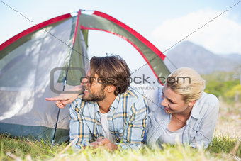 Attractive couple lying in their tent looking at something