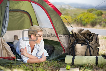 Attractive happy blonde lying in tent