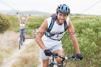 Fit attractive couple cycling on mountain trail