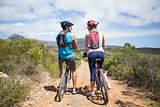 Fit couple about to cycle on mountain trail