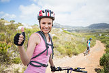 Fit couple cycling on mountain trail woman smiling at camera