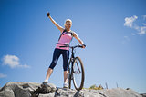 Fit pretty cyclist on a rocky terrain smiling at camera
