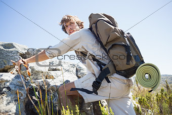 Handsome hiker hiking through rough terrain