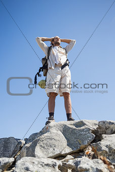 Handsome hiker standing at the summit
