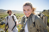 Hiking couple standing on mountain terrain woman smiling at camera