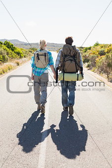 Attractive couple walking on the road holding hands