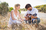 Handsome man serenading his girlfriend with guitar