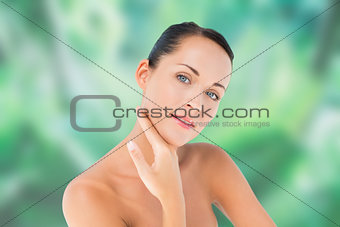 Beautiful nude brunette posing with hand on face