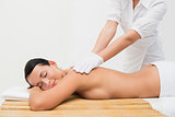 Beautiful brunette enjoying an exfoliating back massage
