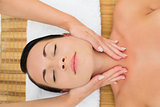 Peaceful brunette enjoying a facial massage