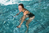 Fit brunette using underwater exercise bike