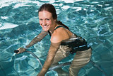 Fit brunette using underwater exercise bike