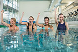 Female fitness class doing aqua aerobics and cheering