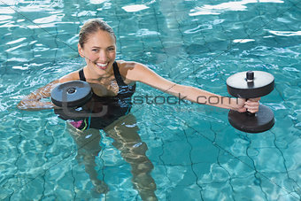 Fit blonde working out with foam dumbbells