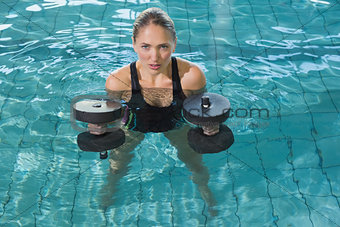 Fit blonde working out with foam dumbbells