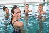 Smiling female fitness class doing aqua aerobics