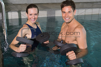 Happy couple working out with foam dumbbells