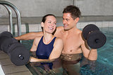 Happy couple working out with foam dumbbells