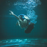 Athletic swimmer doing a somersault underwater
