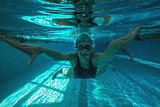 Athletic swimmer swimming towards camera