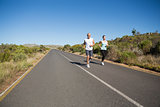 Fit couple running on the open road together